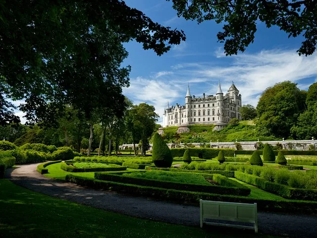 Dunrobin Castle, gesehen von seinen weitläufigen Ziergärten mit gepflegten Hecken und grünen Rasenflächen.