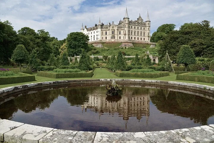 Dunrobin Castle thront über einem Spiegelbecken und gepflegten formalen Gärten.